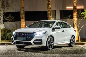 caoa-chery-arrizo-6-pro-hybrid-branco-perolizado-frente-parado-em-estacionamento-com-farois-ligados